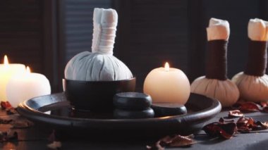 Spa arka planı. Mumlar, masaj taşları ve bitkisel toplar. Masaj, oryantal terapi, refah ve meditasyon.