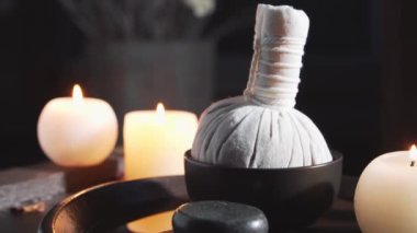 Spa arka planı. Mumlar, masaj taşları ve bitkisel toplar. Masaj, oryantal terapi, refah ve meditasyon.