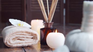 Spa arka planı. Havlu, mumlar, çiçekler, masaj taşları ve bitkisel toplar. Masaj, oryantal terapi, refah ve meditasyon.
