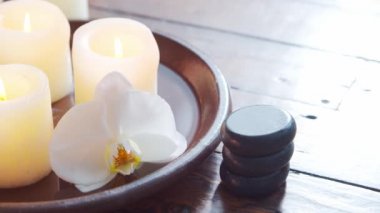 Spa arka planı. Havlu, mumlar, çiçekler, masaj taşları ve bitkisel toplar. Masaj, oryantal terapi, refah ve meditasyon.