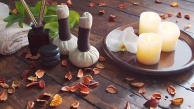 Spa arka planı. Havlu, mumlar, çiçekler, masaj taşları ve bitkisel toplar. Masaj, oryantal terapi, refah ve meditasyon.