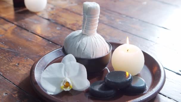 Fond de spa. Serviette, bougies, fleurs, pierres de massage et boules à base de plantes. Massage, thérapie orientale, bien-être et méditation. — Video