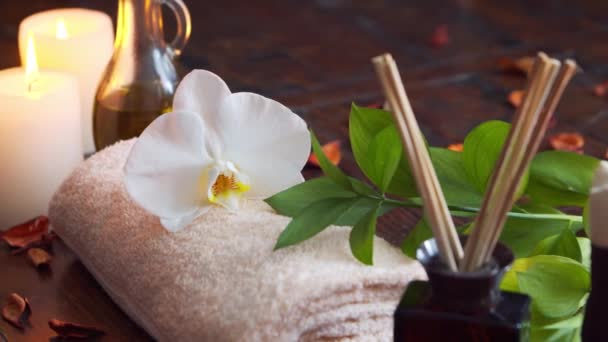 Spa achtergrond. Handdoek, kaarsen, bloemen, massagestenen en kruidenballen. Massage, oosterse therapie, welzijn en meditatie. — Stockvideo