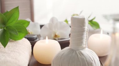 Spa arka planı. Havlu, mumlar, çiçekler, masaj taşları ve bitkisel toplar. Masaj, oryantal terapi, refah ve meditasyon.