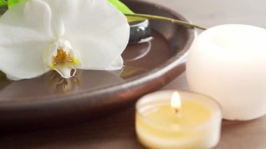 Spa arka planı. Havlu, mumlar, çiçekler, masaj taşları ve bitkisel toplar. Masaj, oryantal terapi, refah ve meditasyon.
