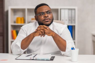 Ev ofisinde serbest tasarımcı işyeri. Genç Afro-Amerikalı bir adam bilgisayar, grafik tableti ve diğer cihazları kullanıyor. Uzak görev.