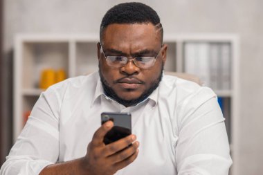 Ev ofisinde serbest tasarımcı işyeri. Genç Afro-Amerikalı bir adam bilgisayar, grafik tableti ve diğer cihazları kullanıyor. Uzak görev.