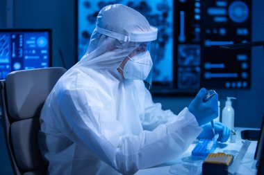 Koruyucu kıyafetli doktor modern bir laboratuvarda bilimsel deneyler yapıyor ve aşı geliştiriyor. Genetik mühendisliği işyeri. Bilim ve tıp kavramı.