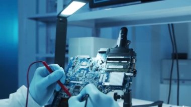 Mikro elektronik mühendisi, bilgisayar sistemleri ve mikroişlemciler üzerine modern bir bilim laboratuvarında çalışıyor. Elektronik fabrika işçisi ana kartı test ediyor ve yazılımı kodluyor..