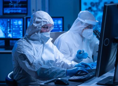 Profesyonel bilim adamları modern bir bilimsel araştırma laboratuvarında bir aşı üzerinde çalışıyorlar. Genetik mühendisliği işyeri. Gelecekteki teknoloji ve bilim konsepti.