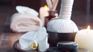 Spa arka planı. Havlu, mumlar, çiçekler, masaj taşları ve bitkisel toplar. Masaj, oryantal terapi, refah ve meditasyon.