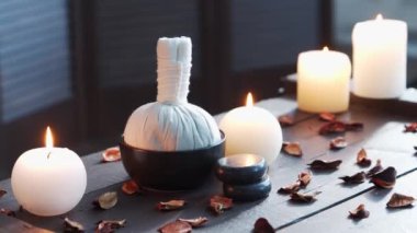 Spa arka planı. Mumlar, masaj taşları ve bitkisel toplar. Masaj, oryantal terapi, refah ve meditasyon.
