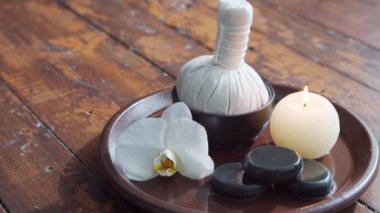 Spa arka planı. Havlu, mumlar, çiçekler, masaj taşları ve bitkisel toplar. Masaj, oryantal terapi, refah ve meditasyon.