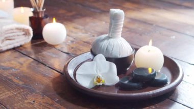 Spa arka planı. Havlu, mumlar, çiçekler, masaj taşları ve bitkisel toplar. Masaj, oryantal terapi, refah ve meditasyon.