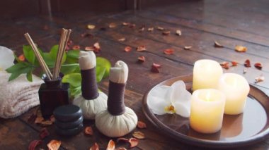 Spa arka planı. Havlu, mumlar, çiçekler, masaj taşları ve bitkisel toplar. Masaj, oryantal terapi, refah ve meditasyon.