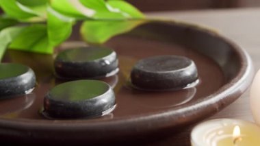 Spa arka planı. Havlu, mumlar, çiçekler, masaj taşları ve bitkisel toplar. Masaj, oryantal terapi, refah ve meditasyon.