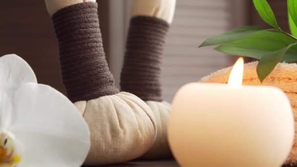 Fundo de spa. Toalha, velas, flores, pedras de massagem e bolas de ervas. Massagem, terapia oriental, bem-estar e meditação. — Vídeo de Stock