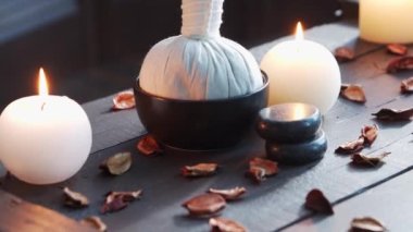 Spa arka planı. Mumlar, masaj taşları ve bitkisel toplar. Masaj, oryantal terapi, refah ve meditasyon.