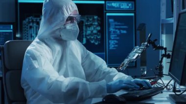 Mikro elektronik mühendisi, bilgisayar sistemleri ve mikroişlemciler üzerine modern bir bilim laboratuvarında çalışıyor. Elektronik fabrika işçisi ana kartı test ediyor ve yazılımı kodluyor..