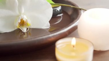 Spa arka planı. Havlu, mumlar, çiçekler, masaj taşları ve bitkisel toplar. Masaj, oryantal terapi, refah ve meditasyon.