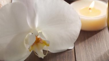 Spa arka planı. Havlu, mumlar, çiçekler, masaj taşları ve bitkisel toplar. Masaj, oryantal terapi, refah ve meditasyon.