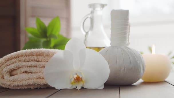 Sfondo Spa. Asciugamano, candele, fiori, pietre massaggianti e palline alle erbe. Massaggio, terapia orientale, benessere e meditazione. — Video Stock