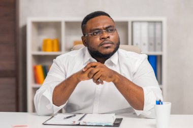 Ev ofisinde serbest tasarımcı işyeri. Genç Afro-Amerikalı bir adam bilgisayar, grafik tableti ve diğer cihazları kullanıyor. Uzak görev.