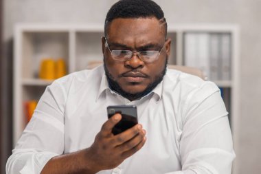 Ev ofisinde serbest tasarımcı işyeri. Genç Afro-Amerikalı bir adam bilgisayar, grafik tableti ve diğer cihazları kullanıyor. Uzak görev.