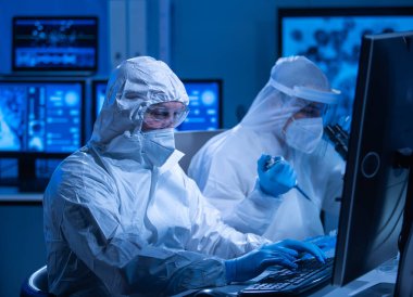 Profesyonel bilim adamları modern bir bilimsel araştırma laboratuvarında bir aşı üzerinde çalışıyorlar. Genetik mühendisliği işyeri. Gelecekteki teknoloji ve bilim konsepti.