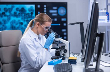 Profesyonel kadın bilim adamı bir bilimsel araştırma laboratuvarında aşı üzerinde çalışıyor. Genetik mühendisliği işyeri. Teknoloji ve bilim konsepti.