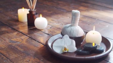Spa arka planı. Havlu, mumlar, çiçekler, masaj taşları ve bitkisel toplar. Masaj, oryantal terapi, refah ve meditasyon.