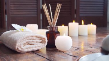 Spa arka planı. Havlu, mumlar, çiçekler, masaj taşları ve bitkisel toplar. Masaj, oryantal terapi, refah ve meditasyon.