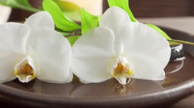 Spa arka planı. Havlu, mumlar, çiçekler, masaj taşları ve bitkisel toplar. Masaj, oryantal terapi, refah ve meditasyon.