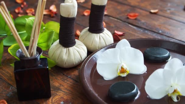 Fond de spa. Serviette, bougies, fleurs, pierres de massage et boules à base de plantes. Massage, thérapie orientale, bien-être et méditation. — Video