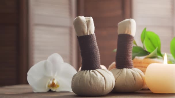 Spa achtergrond. Handdoek, kaarsen, bloemen, massagestenen en kruidenballen. Massage, oosterse therapie, welzijn en meditatie. — Stockvideo