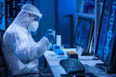 Koruyucu kıyafetli doktor modern bir laboratuvarda bilimsel deneyler yapıyor ve aşı geliştiriyor. Genetik mühendisliği işyeri. Bilim ve tıp kavramı.