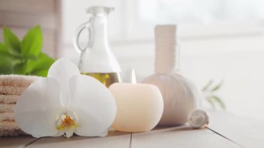 Spa arka planı. Havlu, mumlar, çiçekler, masaj taşları ve bitkisel toplar. Masaj, oryantal terapi, refah ve meditasyon.
