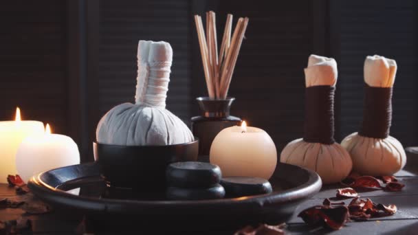 Spa background. Candles, massaging stones and herbal balls. Massage, oriental therapy, wellbeing and meditation. — Stock Video