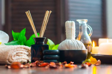Spa arka planı. Havlu, mumlar, çiçekler, aroma çubukları, masaj taşları ve bitkisel toplar. Masaj, oryantal terapi, refah ve meditasyon.