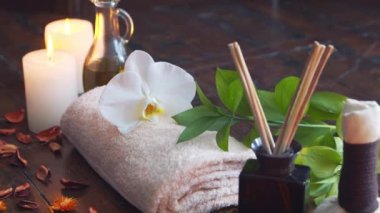 Spa arka planı. Havlu, mumlar, çiçekler, masaj taşları ve bitkisel toplar. Masaj, oryantal terapi, refah ve meditasyon.