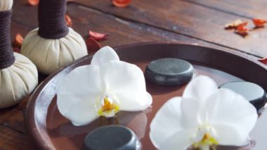 Spa arka planı. Havlu, mumlar, çiçekler, masaj taşları ve bitkisel toplar. Masaj, oryantal terapi, refah ve meditasyon.