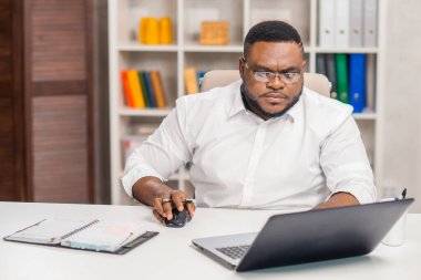 Ev ofisinde serbest tasarımcı işyeri. Genç Afro-Amerikalı bir adam bilgisayar, grafik tableti ve diğer cihazları kullanıyor. Uzak görev.