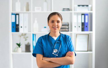 Hastane ofisinde çalışan profesyonel tıp doktoru koruyucu maskeli genç ve çekici bir kadın doktorun portresi. Tıbbi konsept.