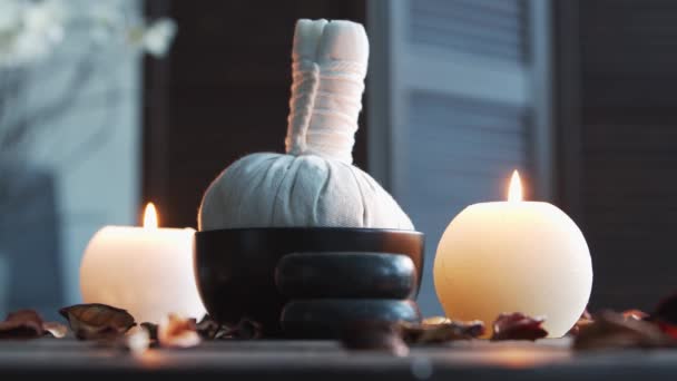 Spa background. Towel, candles, flowers, massaging stones and herbal balls. Massage, oriental therapy, wellbeing and meditation. — Stock Video