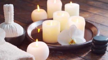 Spa arka planı. Havlu, mumlar, çiçekler, masaj taşları ve bitkisel toplar. Masaj, oryantal terapi, refah ve meditasyon.