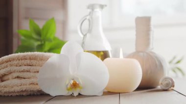 Spa arka planı. Havlu, mumlar, çiçekler, masaj taşları ve bitkisel toplar. Masaj, oryantal terapi, refah ve meditasyon.