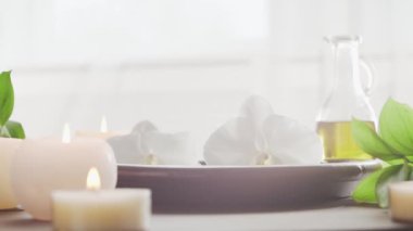 Spa arka planı. Havlu, mumlar, çiçekler, masaj taşları ve bitkisel toplar. Masaj, oryantal terapi, refah ve meditasyon.