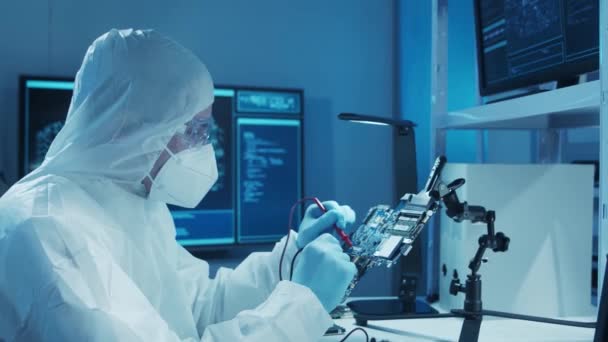 Microelectronics engineer works in a modern scientific laboratory on computing systems and microprocessors. Electronic factory worker is testing the motherboard and coding the firmware. — Stock Video