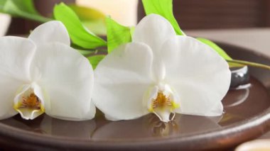 Spa arka planı. Havlu, mumlar, çiçekler, masaj taşları ve bitkisel toplar. Masaj, oryantal terapi, refah ve meditasyon.