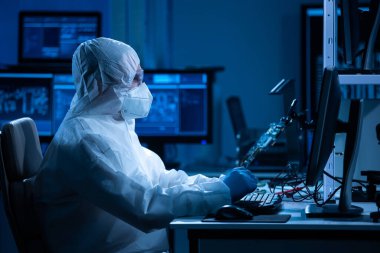 Mikro elektronik mühendisi, bilgisayar sistemleri ve mikroişlemciler üzerine modern bir bilim laboratuvarında çalışıyor. Elektronik fabrika işçisi ana kartı test ediyor ve yazılımı kodluyor..